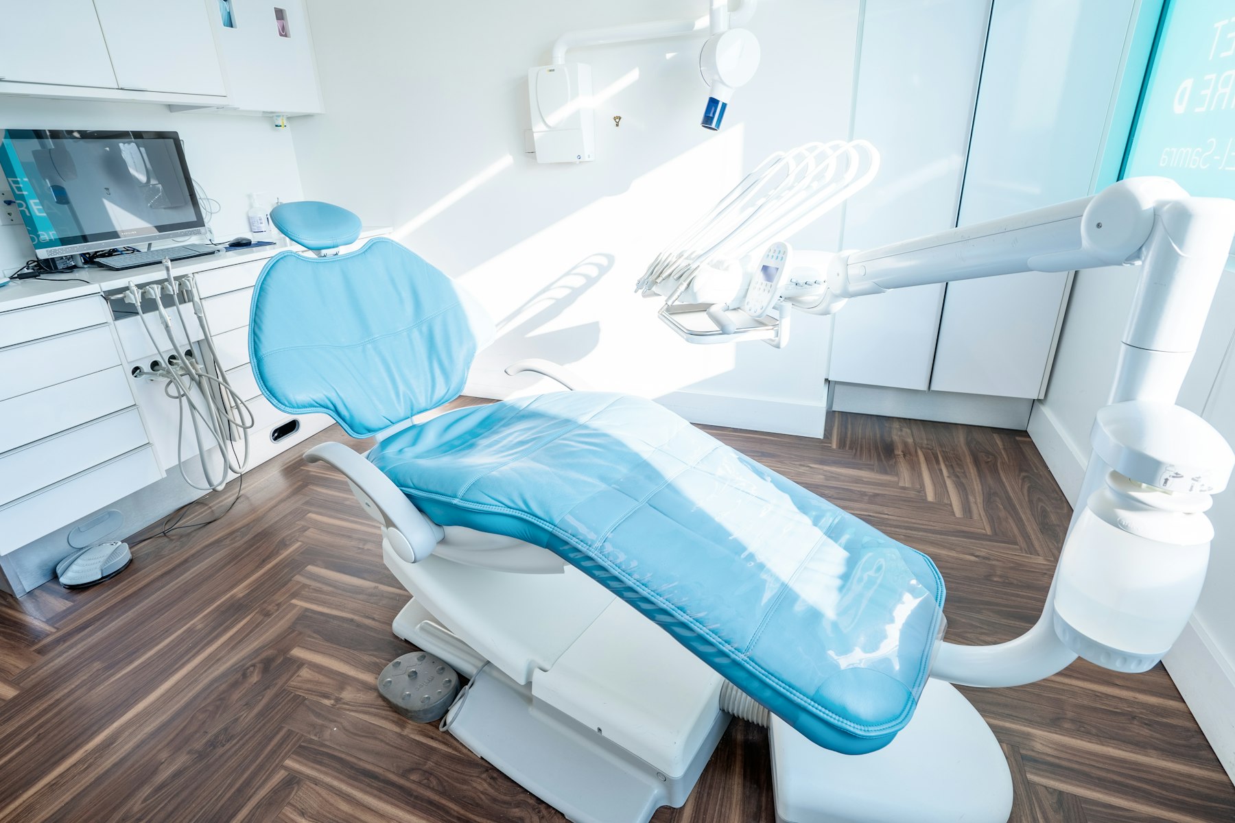 Bright, modern dental treatment room with a clean chair and warm timber floor