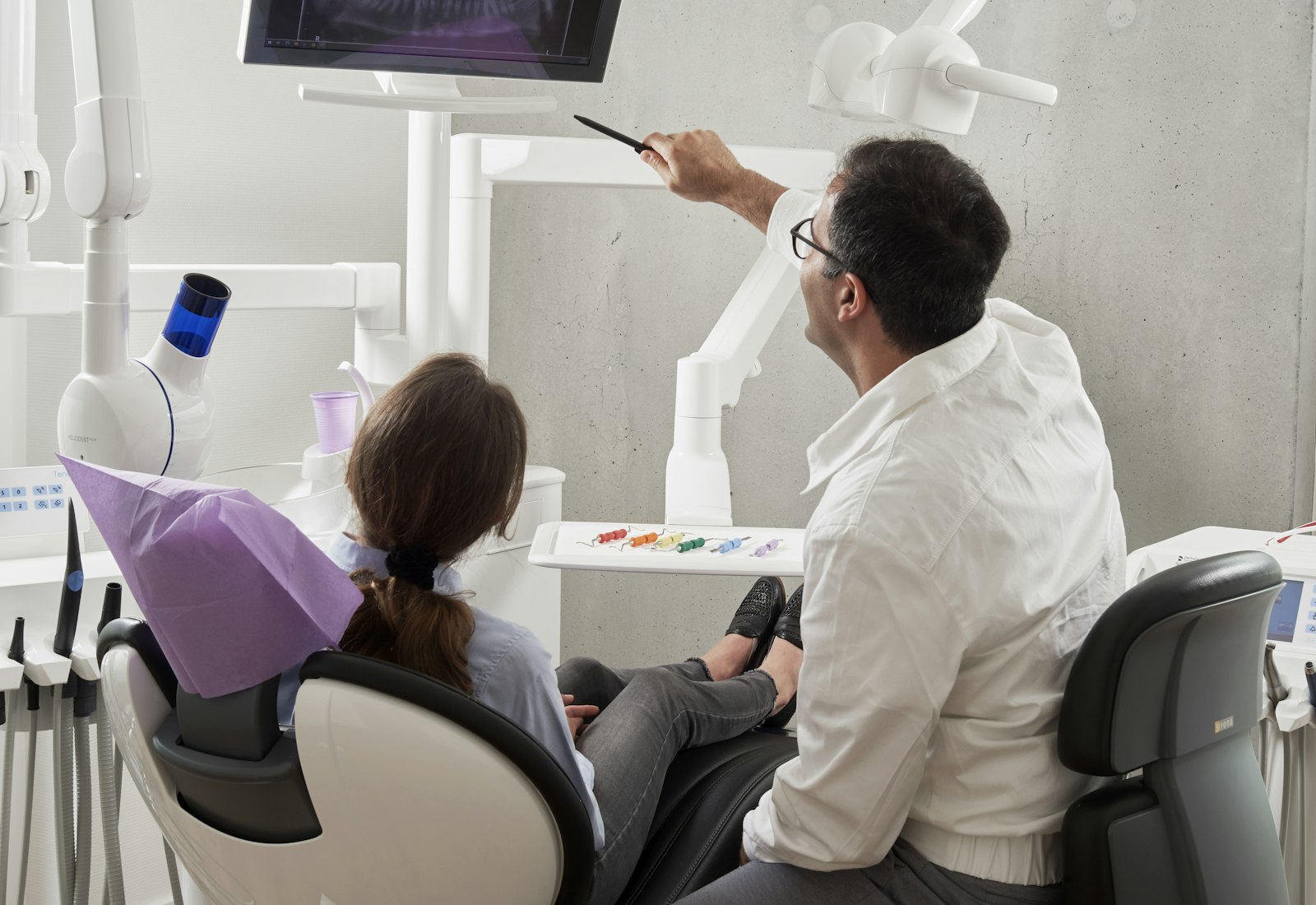 A Māhū dentist gently talking a patient through their treatment