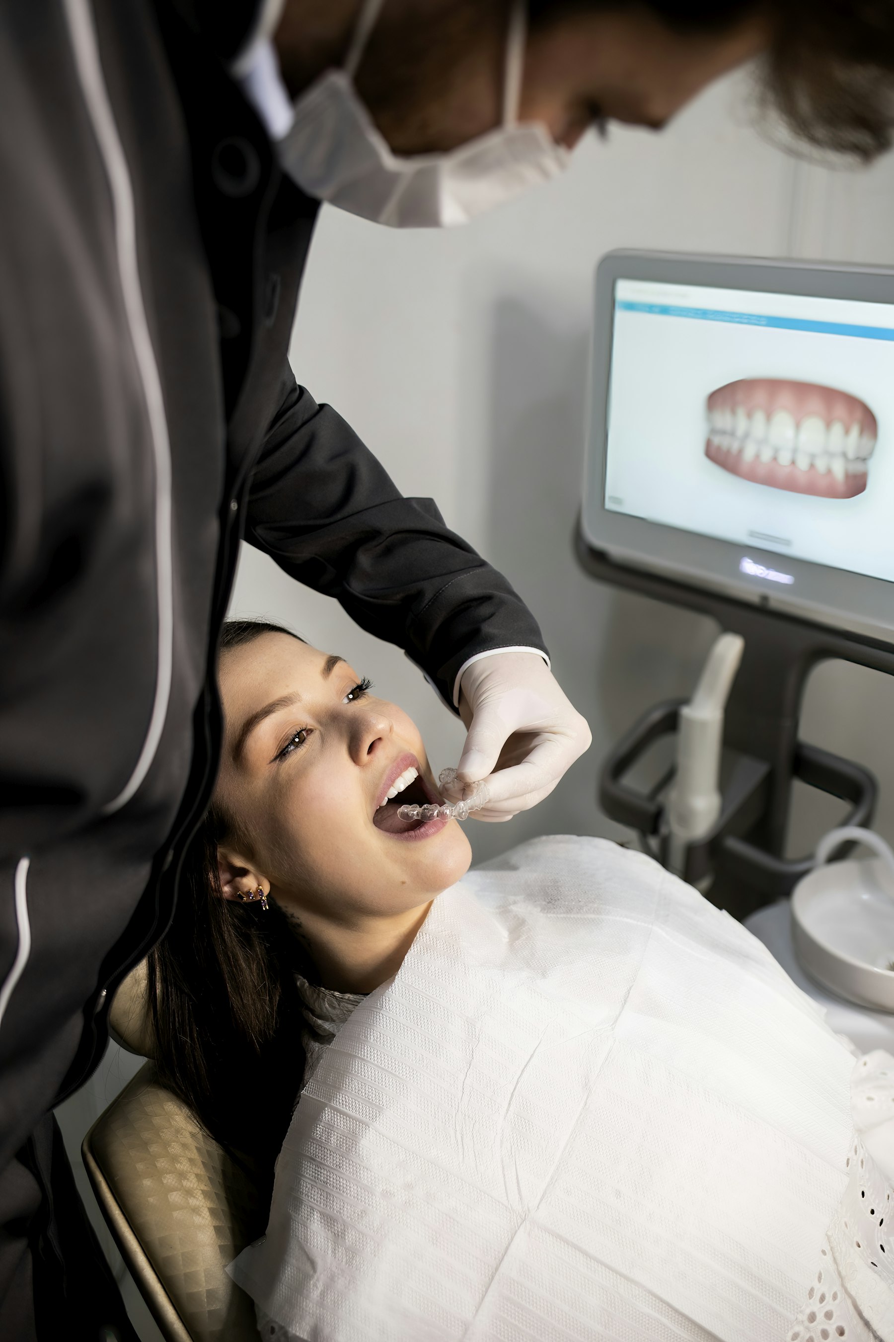 A dentist examining a patient with a modern intraoral scanner