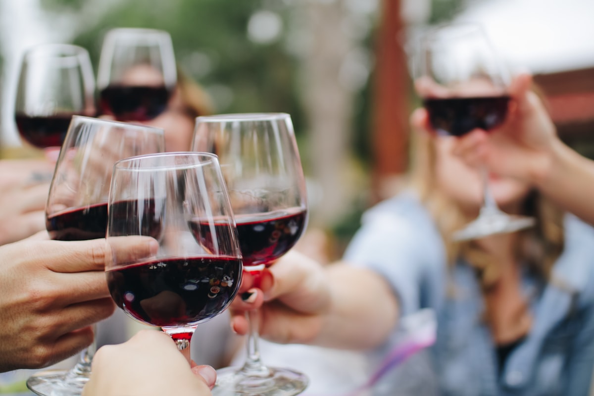 Friends raising glasses of red wine together