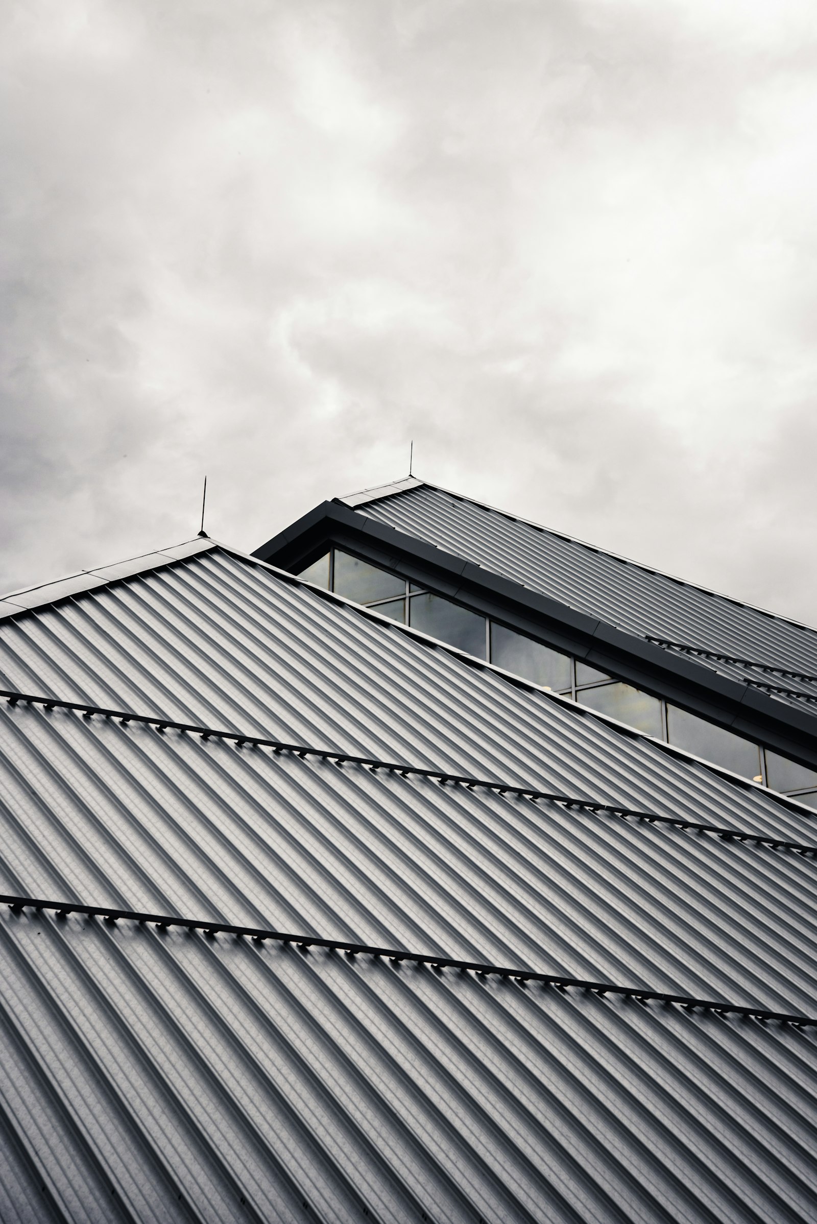 Steel roof gable under a heavy Auckland sky